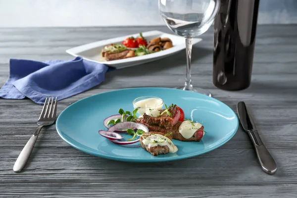 Filete en rodajas servido con verduras y salsa blanca en plato azul —  Fotos de Stock