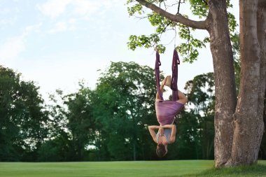 Kadın hava yogası yapıyor. 