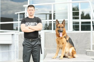 Güvenlik görevlisi ile köpek building yakınındaki
