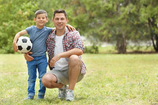 Mutlu baba ve oğul futbol topu parkta ile