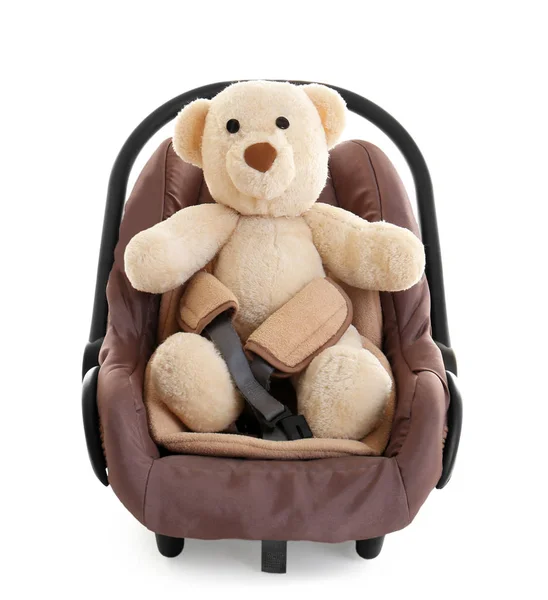 Cute teddy bear in child safety seat isolated on white — Stock Photo, Image