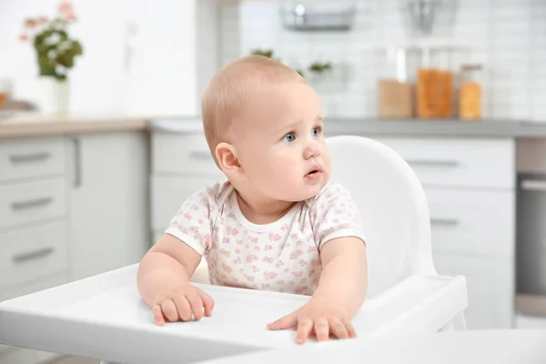 Cute baby sitting in kitchen — Stock Photo, Image