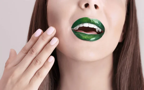 Giovane bella donna con fantasia rossetto verde su sfondo di colore, primo piano — Foto Stock