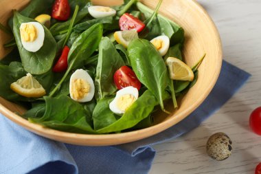 Ispanak yaprakları ve ahşap masa üzerinde bir kapta yumurta salatası