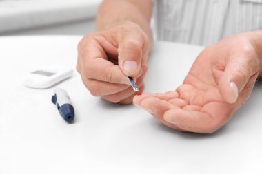 Glikoz düzeyi için kapalı test şeridi kullanan adam