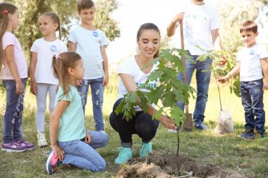 Parkta ağaç dikme çocuklu genç gönüllüler