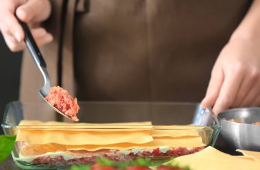 Kadın mutfakta lazanya hazırlıyor.