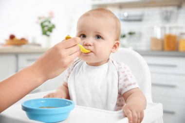 Mutfakta kaşıkla besleme bebek anne