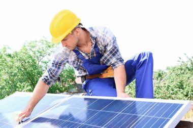 Dışarıda güneş panelleri kuran işçiler