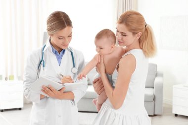 Doktor bir şey defter ve bebek evde annesiyle yazma