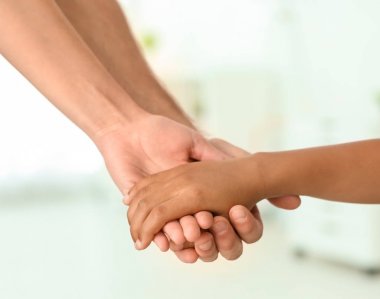 Küçük Afrikalı-Amerikalı çocuğun elini tutarak anne arka plan ışık. Evlat edinme kavramı