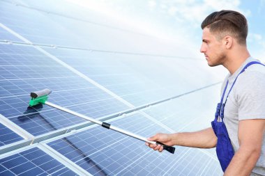 Genç bir işçi güneş panelleri yükleme açık havada sonra yıkama