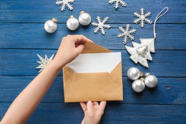 Noel mektubu zarfa ahşap masa içine koyarak kadın