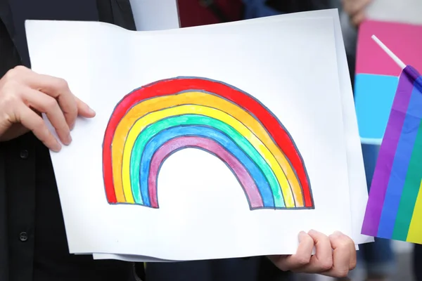 Concepto de minoría sexual. Hombre sosteniendo imagen de arco iris al aire libre —  Fotos de Stock