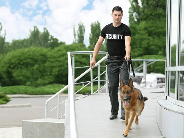 Security guard with dog near building