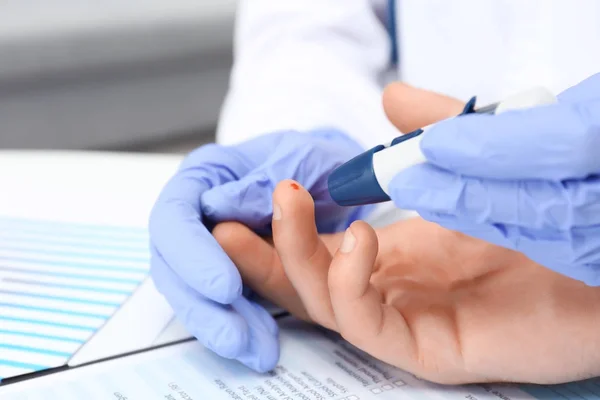 Lekarz w Rękawice lateksowe pobranie próbki krwi pacjenta przy użyciu pióra lancetu. Koncepcja cukrzycy — Zdjęcie stockowe