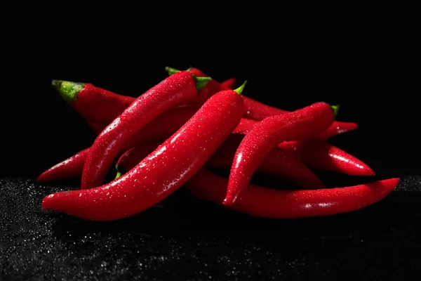 Rode chili pepers op zwarte achtergrond — Stockfoto