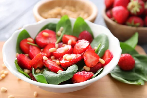 Teller Salat mit Spinat, Erdbeere und Pinienkernen an Bord — Stockfoto