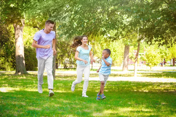 Junge Familie mit adoptiertem afrikanisch-amerikanischem Jungen hat Spaß im Freien — Stockfoto