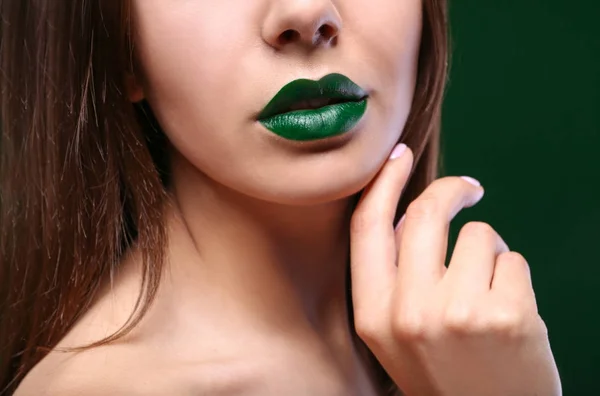 Joven hermosa mujer con lápiz labial verde de lujo sobre fondo oscuro, primer plano —  Fotos de Stock