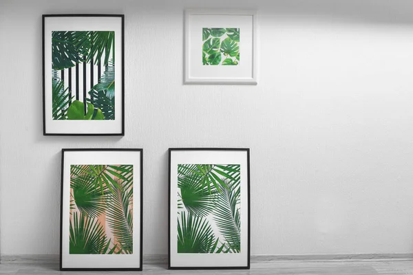 Картины в рамке тропических листьев на фоне белой стены — стоковое фото