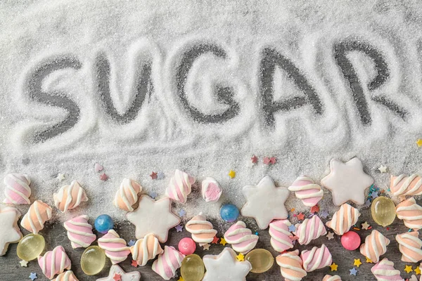Composición con azúcar blanco y variedad de caramelos sobre fondo gris — Foto de Stock