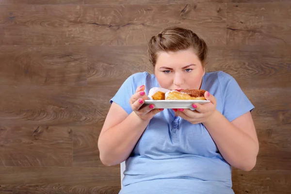 お菓子を食べて太りすぎの女性 — ストック写真