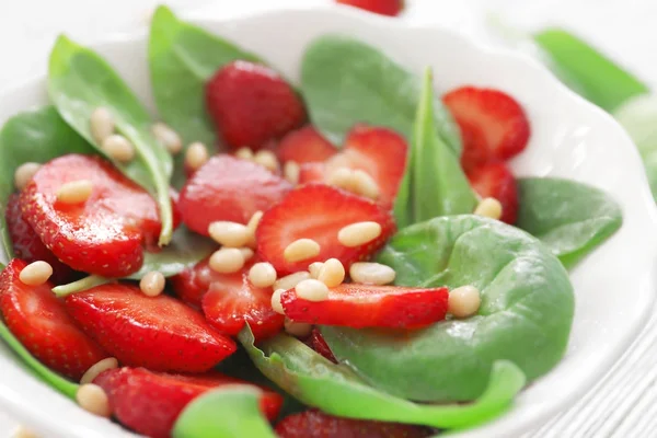 Salat mit Spinat, Erdbeere und Pinienkernen im Teller, Nahaufnahme — Stockfoto