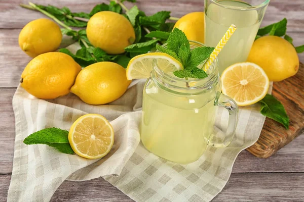 Hermosa composición con tarro de albañil de jugo de limón fresco en mesa de madera —  Fotos de Stock