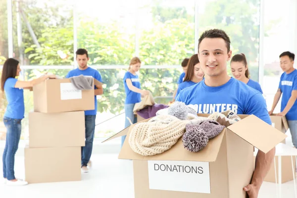 Happy Teen Volunteer Boy Holding Box Donated Clothes Indoors — Stock Photo, Image