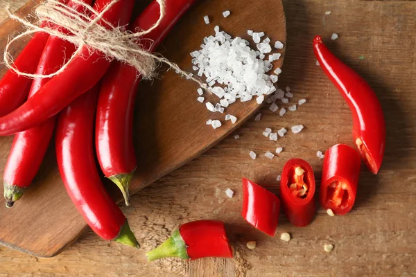 Chili peppers on wooden board — Stock Photo, Image