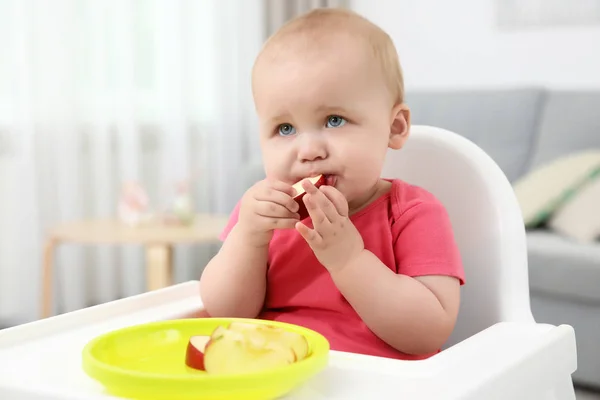 Pequeno bebê comendo maçã dentro de casa — Fotografia de Stock