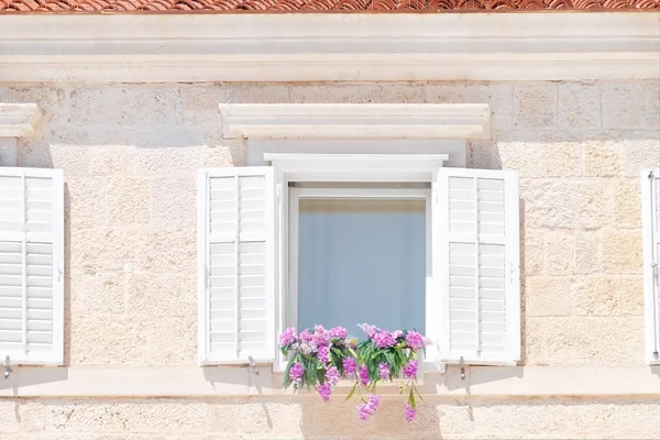 Vue de maison en pierre avec des fleurs sur la fenêtre — Photo