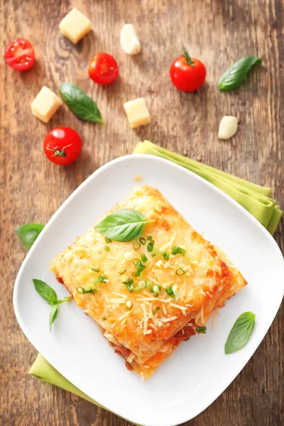 Tallrik med lasagne på träbord — Stockfoto