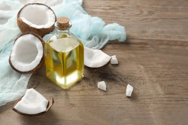 Botella con aceite de coco fresco sobre mesa de madera — Foto de Stock