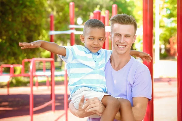 Joven padre con adoptado afroamericano chico al aire libre — Foto de Stock