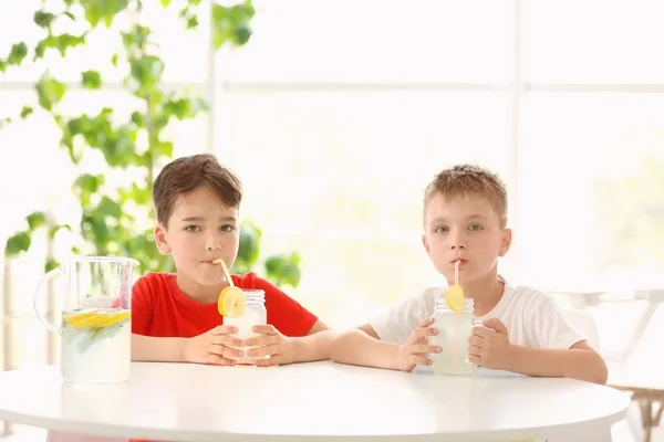 Bonitos meninos bebendo limonada fresca no café — Fotografia de Stock