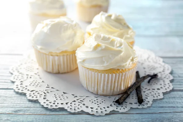 Tasty vanilla cupcakes on wooden table — Stock Photo, Image