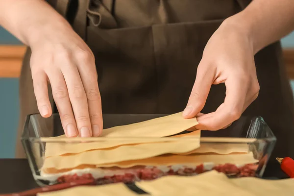 Woman preparing meat lasagna in kitchen — Stock Photo, Image