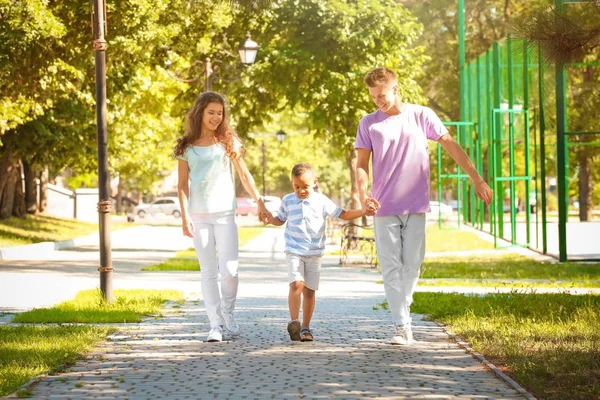 Familia joven con niño afroamericano adoptado en el parque — Foto de Stock