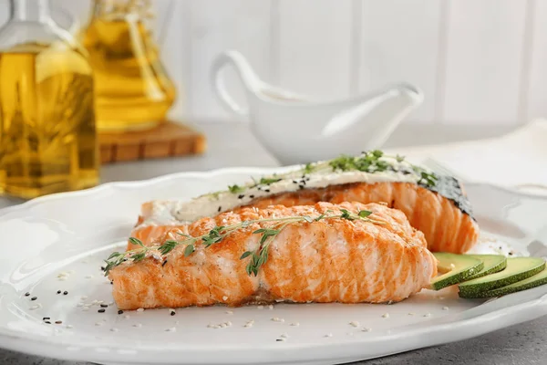 Тарілка зі смачним лососем і рибним соусом на столі — стокове фото
