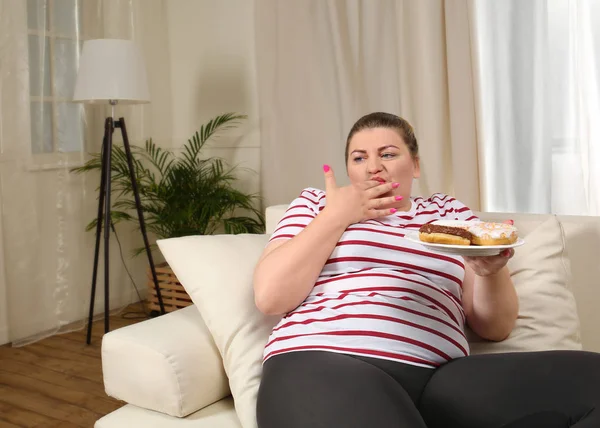 Übergewichtige Frau isst Süßigkeiten — Stockfoto