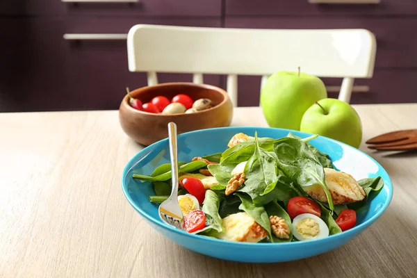 Plate of tasty salad with spinach leaves  on wooden table — Stock Photo, Image