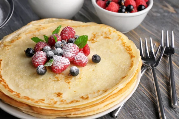 Stack of thin pancakes served with raspberry, black currant and sugar powder — Stock Photo, Image