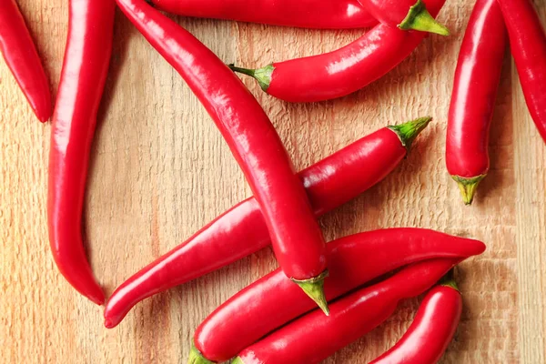 Červená chilli paprika na dřevěném pozadí — Stock fotografie