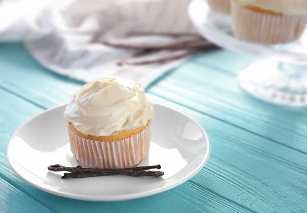 Plate with tasty vanilla cupcake on table — Stock Photo, Image