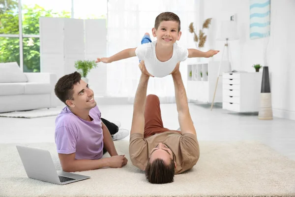 Pareja gay masculina jugando con un hijo adoptivo. Concepto de adopción — Foto de Stock