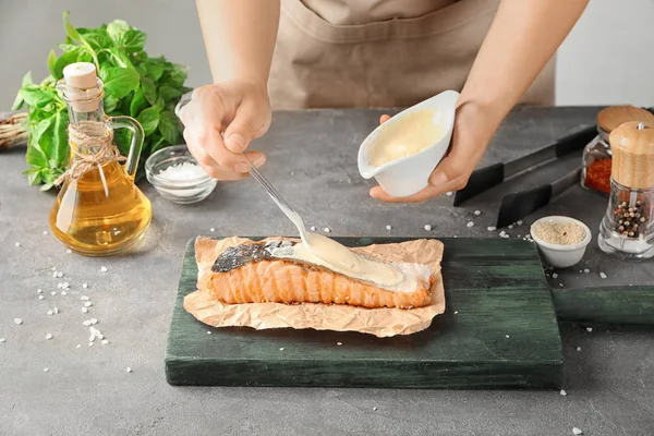 Woman pouring fish sauce on delicious salmon — Stock Photo, Image