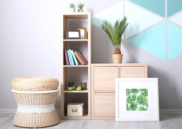 Moderno diseño de la habitación con cuadro enmarcado de hojas tropicales, librería y palma de sagú —  Fotos de Stock