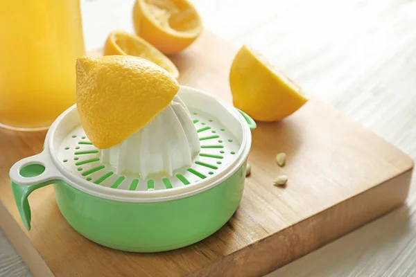 Espremedor de limão na placa de madeira — Fotografia de Stock